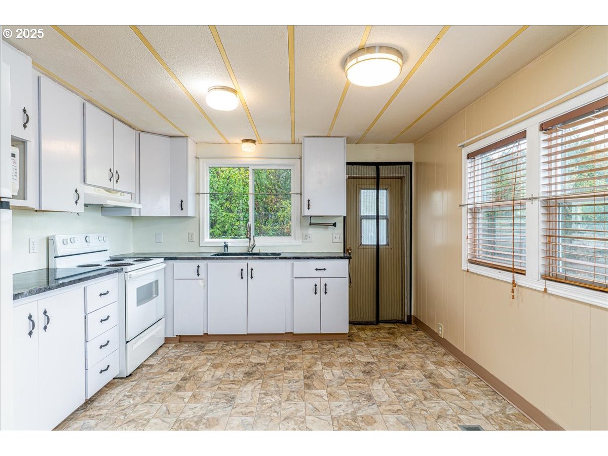 5510 Windsor Island Road North, Unit 19 Keizer, OR 97303 - Photo 11 of 32 a kitchen with granite countertop a stove a sink and a refrigerator