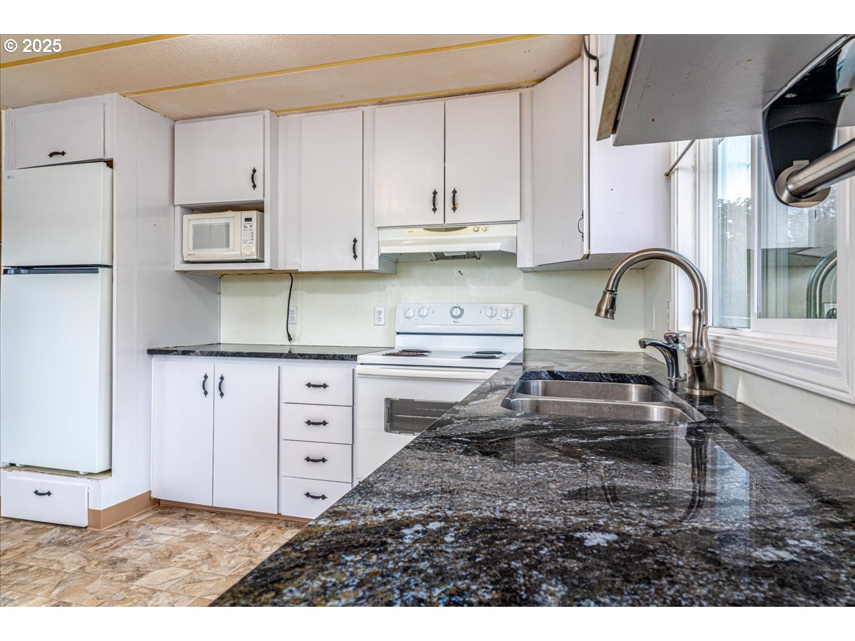 5510 Windsor Island Road North, Unit 19 Keizer, OR 97303 - Photo 13 of 32 a kitchen with stainless steel appliances granite countertop a stove a sink and a refrigerator