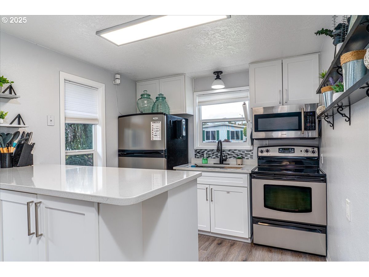 5510 Windsor Island Road North, Unit 19 Keizer, OR 97303 - Photo 31 of 32 a kitchen with stainless steel appliances a stove microwave and sink