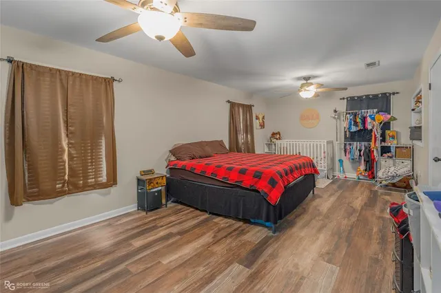 a spacious bedroom with a bed and a dresser next to a window