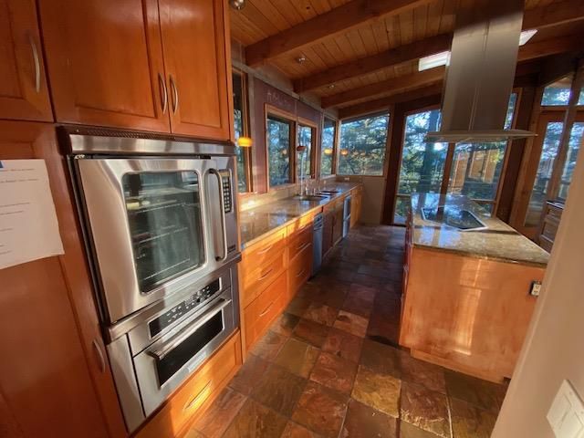 a kitchen with stainless steel appliances granite countertop a refrigerator a stove and a sink with granite countertops