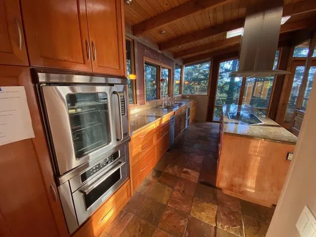 a kitchen with stainless steel appliances granite countertop a refrigerator a stove and a sink with granite countertops
