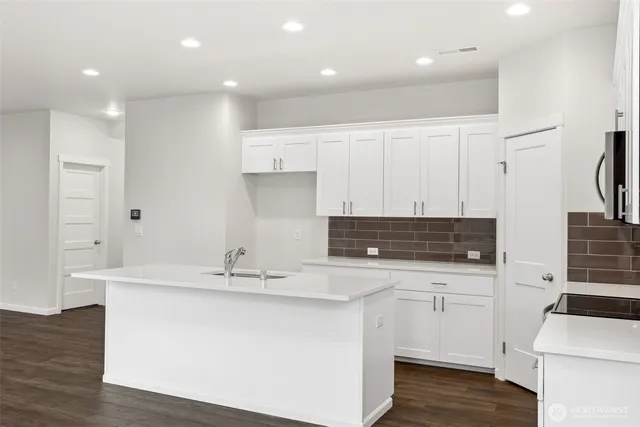 a kitchen with kitchen island a sink stainless steel appliances and cabinets