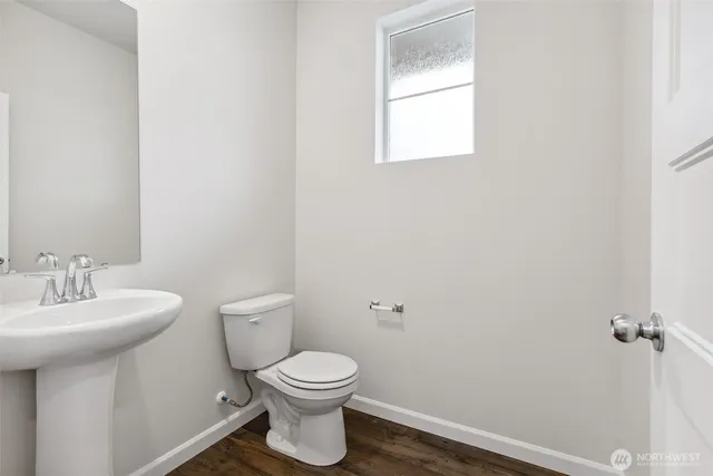 a bathroom with a toilet a sink and mirror