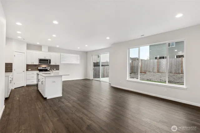 a view of kitchen with stainless steel appliances kitchen island wooden floor and window