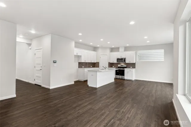 a kitchen with a refrigerator and a stove top oven