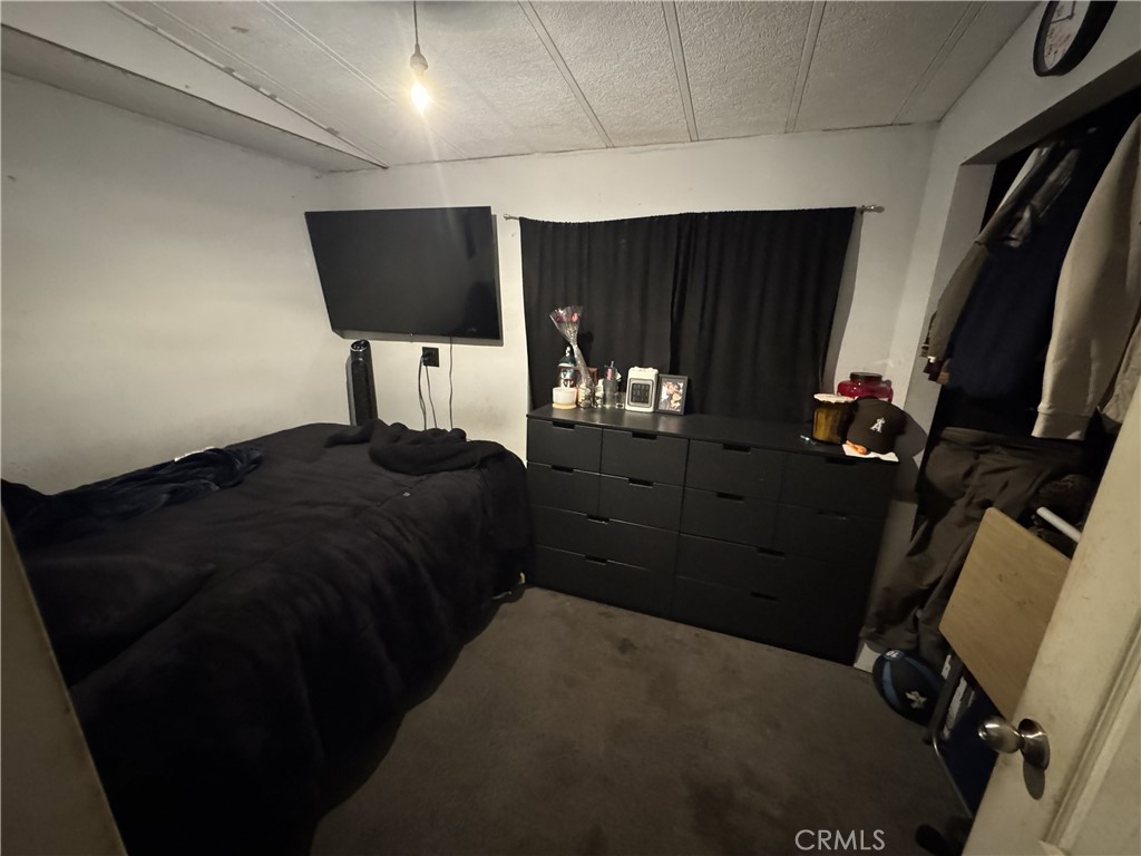 1414 West Central Avenue, Unit 19 Brea, CA 92821 - Photo 5 of 9 a bedroom with a bed closet and television