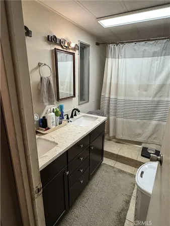 a bathroom with a double vanity sink a mirror and a bathtub
