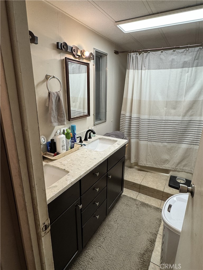 1414 West Central Avenue, Unit 19 Brea, CA 92821 - Photo 7 of 9 a bathroom with a double vanity sink a mirror and a bathtub