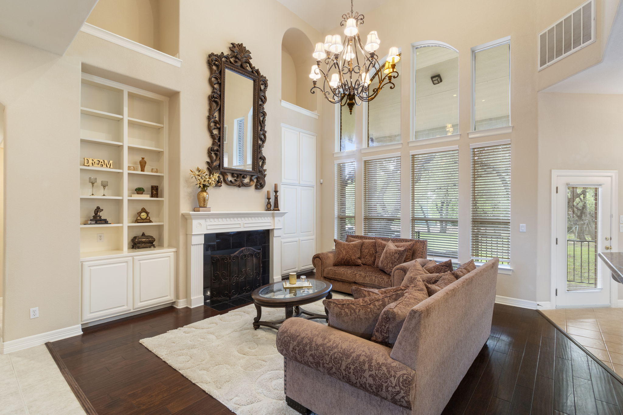 15 Sarazen Loop North Georgetown, TX 78628 - Photo 12 of 40 Living room featuring a high ceiling, dark wood-type flooring, a fireplace with flush hearth, a chandelier, and baseboards