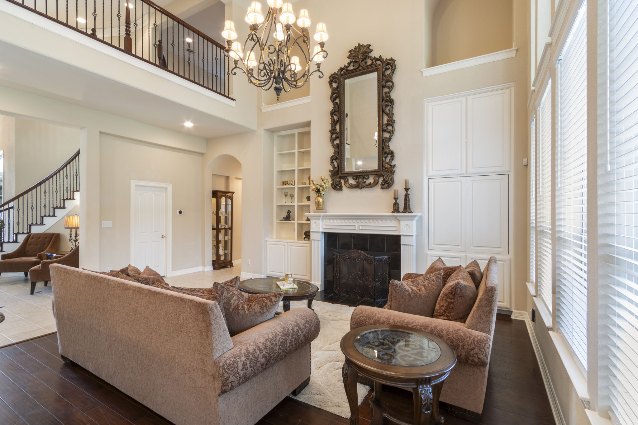 15 Sarazen Loop North Georgetown, TX 78628 - Photo 14 of 40 Living area with a high ceiling, healthy amount of natural light, built in features, dark wood-style flooring, and a tiled fireplace