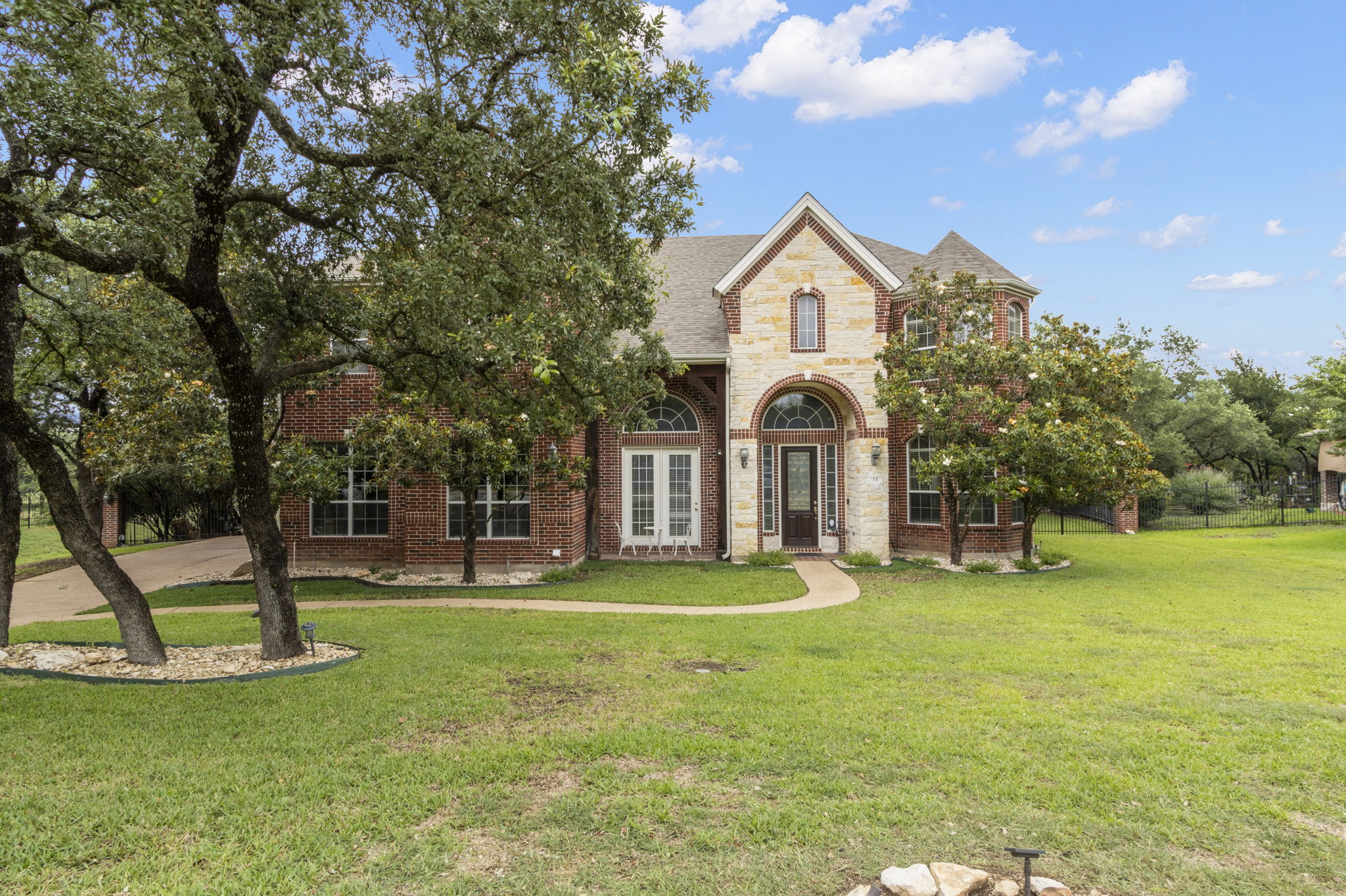 15 Sarazen Loop North Georgetown, TX 78628 - Photo 2 of 40 View of front facade with a front lawn, brick siding, and roof with shingles