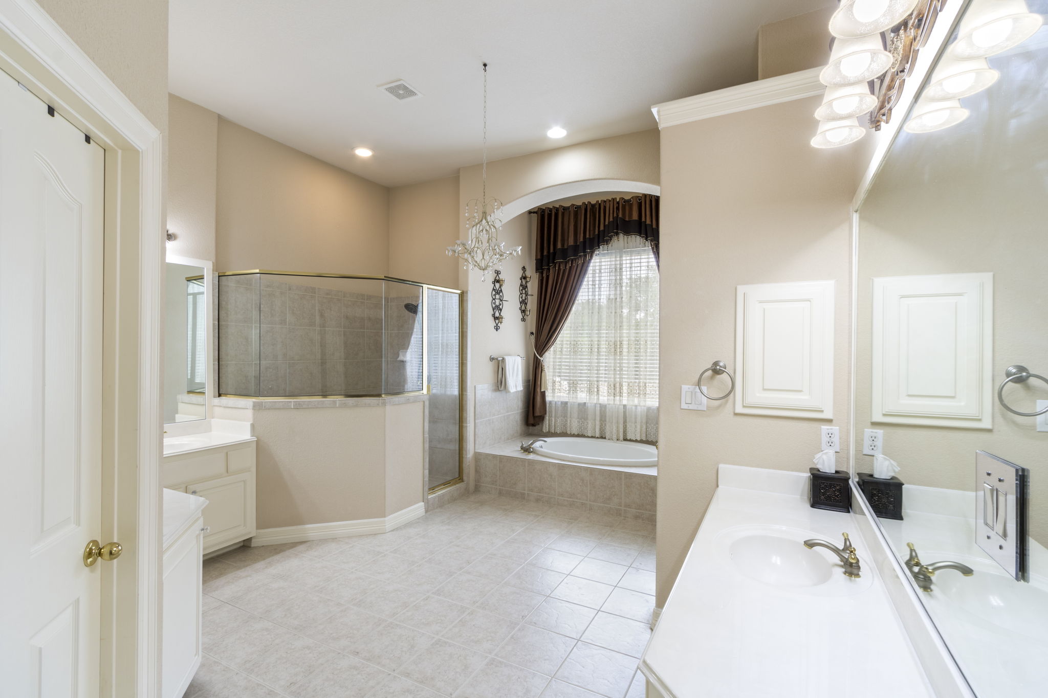 15 Sarazen Loop North Georgetown, TX 78628 - Photo 23 of 40 Bathroom with vanity, a chandelier, a garden tub, a stall shower, and tile patterned floors