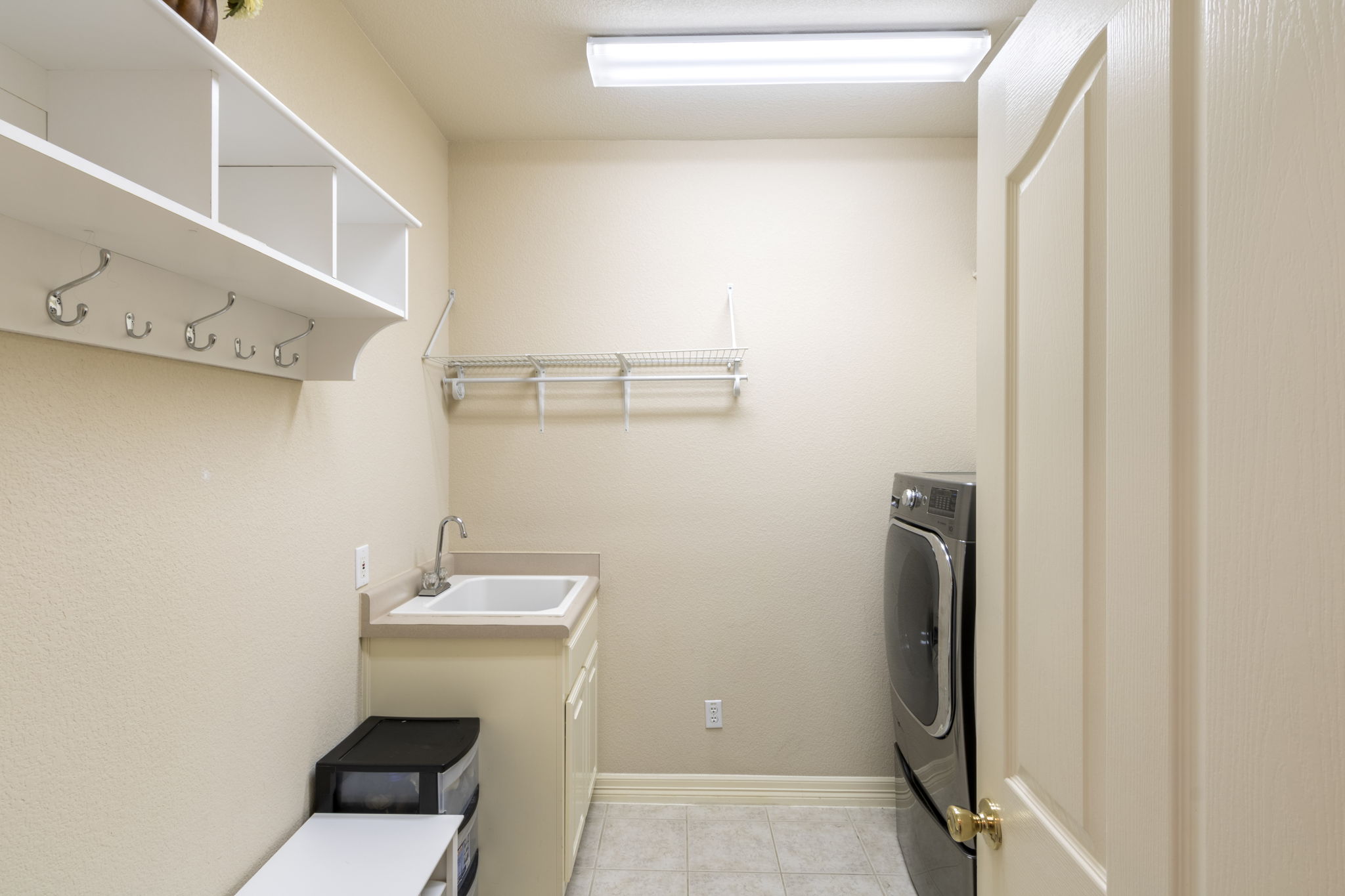 15 Sarazen Loop North Georgetown, TX 78628 - Photo 25 of 40 Laundry area featuring washer / dryer, cabinet space, light tile patterned floors, and baseboards