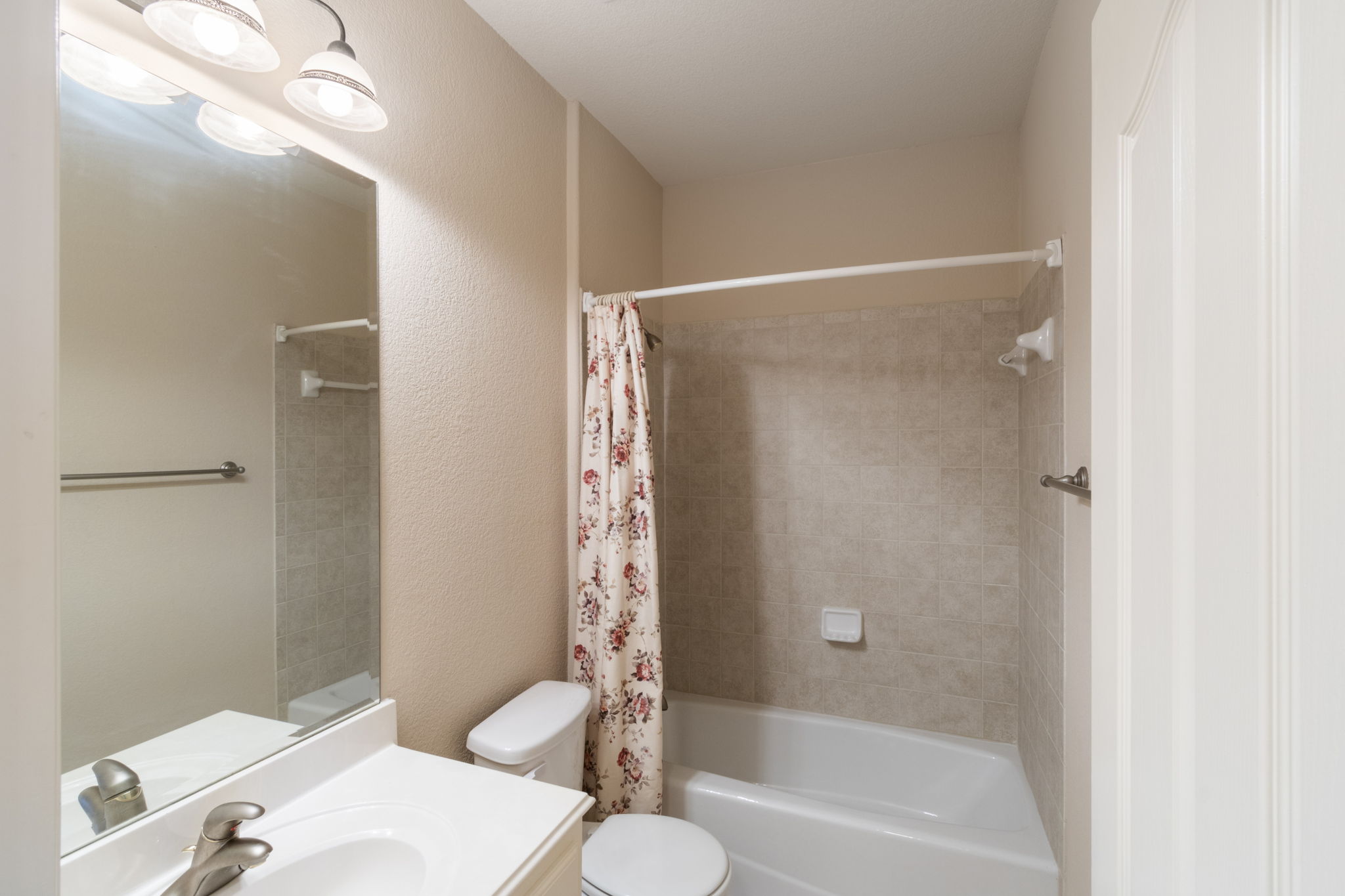15 Sarazen Loop North Georgetown, TX 78628 - Photo 34 of 40 Bathroom featuring vanity, toilet, shower / bath combo with shower curtain, and a textured wall