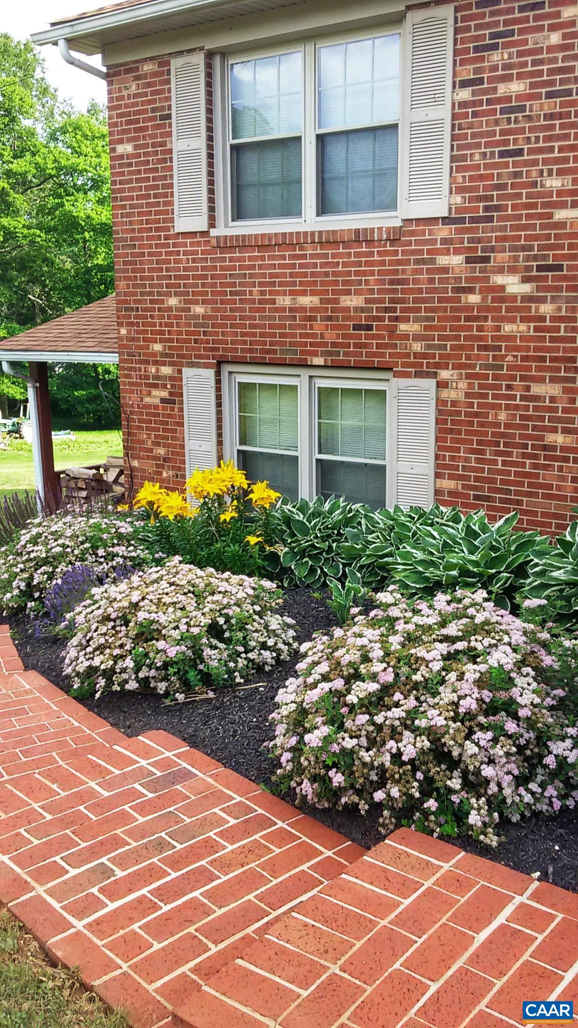 384 Carpenters Mill Road Ruckersville, VA 22968 - Photo 1 of 27 a view of a brick house with a yard