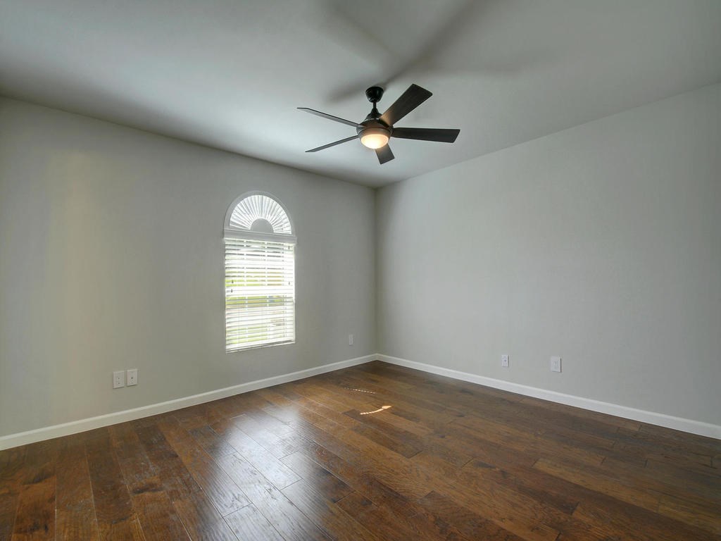 3110 Red River Street, Unit 206 Austin, TX 78705 - Photo 10 of 11 an empty room with wooden floor fan and windows