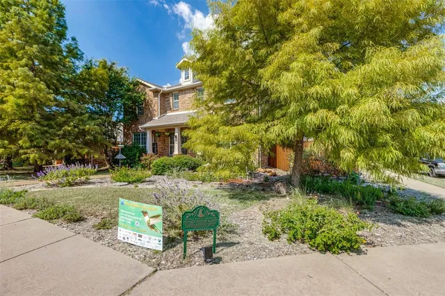 front view of a house with a yard and potted plants