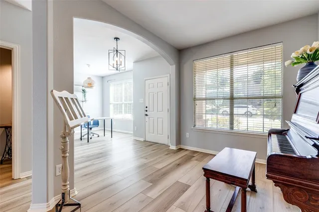 a view of a hallway with wooden floor and a living room