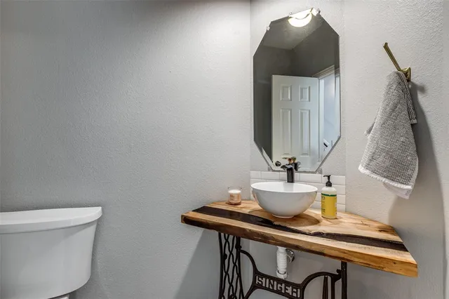 a kitchen with stainless steel appliances a sink a stove a refrigerator cabinets and a dining table