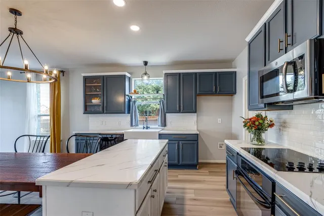 a kitchen with counter top space a sink appliances and cabinets