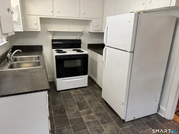 a white refrigerator freezer and a stove sitting inside of a kitchen