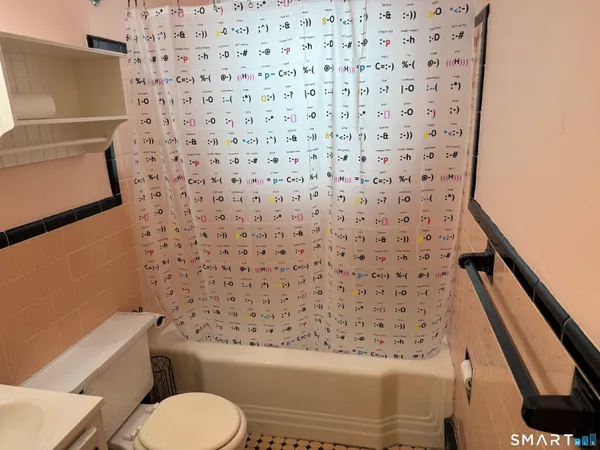a bathroom with a toilet and a shower curtain