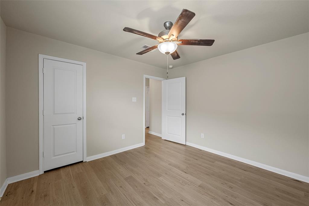 3205 Dottavio Road Lorena, TX 76655 - Photo 24 of 33 Bright interior space featuring light-toned walls, wood-finish flooring, a ceiling fan with integrated lighting, and white paneled doors