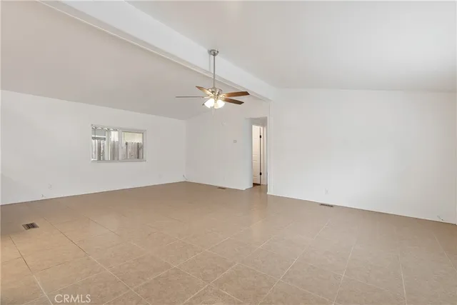 an empty room with a ceiling fan and window