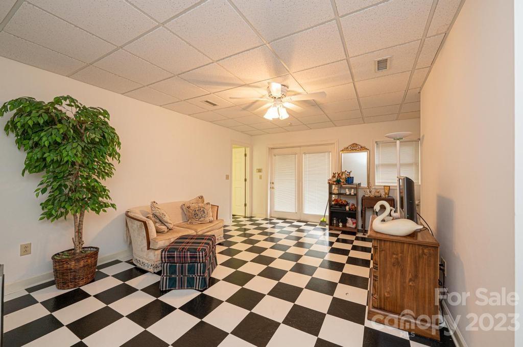 3808 Grace Chapel Road Granite Falls, NC 28630 - Photo 32 of 48 a room with a black white checkered floor with couches chair and a coffee table