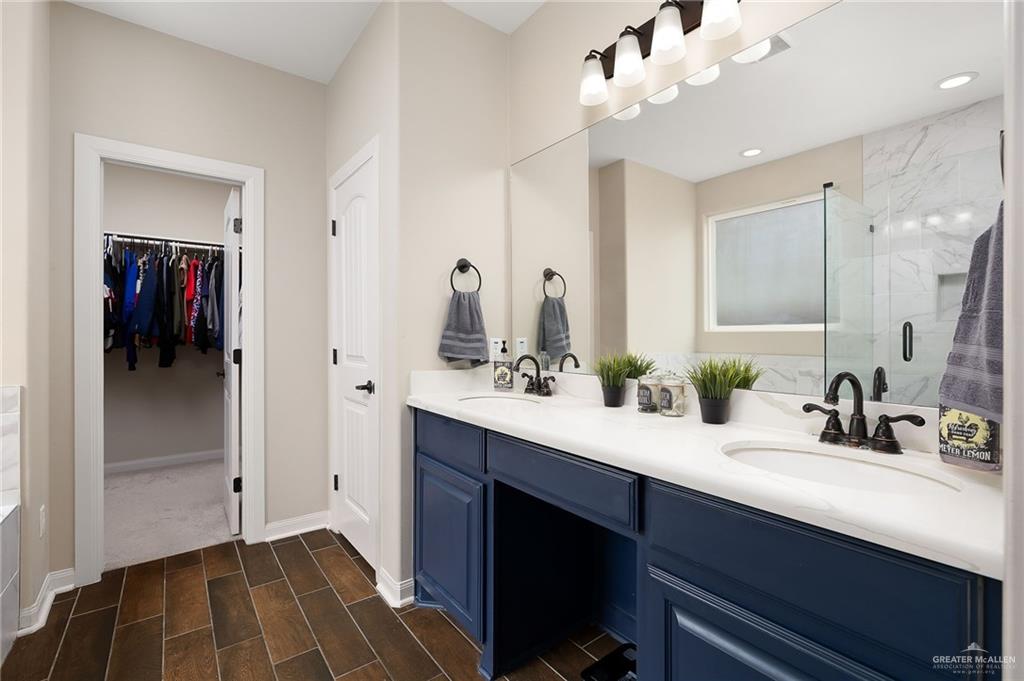 6323 Cascada Bnd Road McAllen, TX 78504 - Photo 16 of 26 a bathroom with a double vanity sink and a mirror
