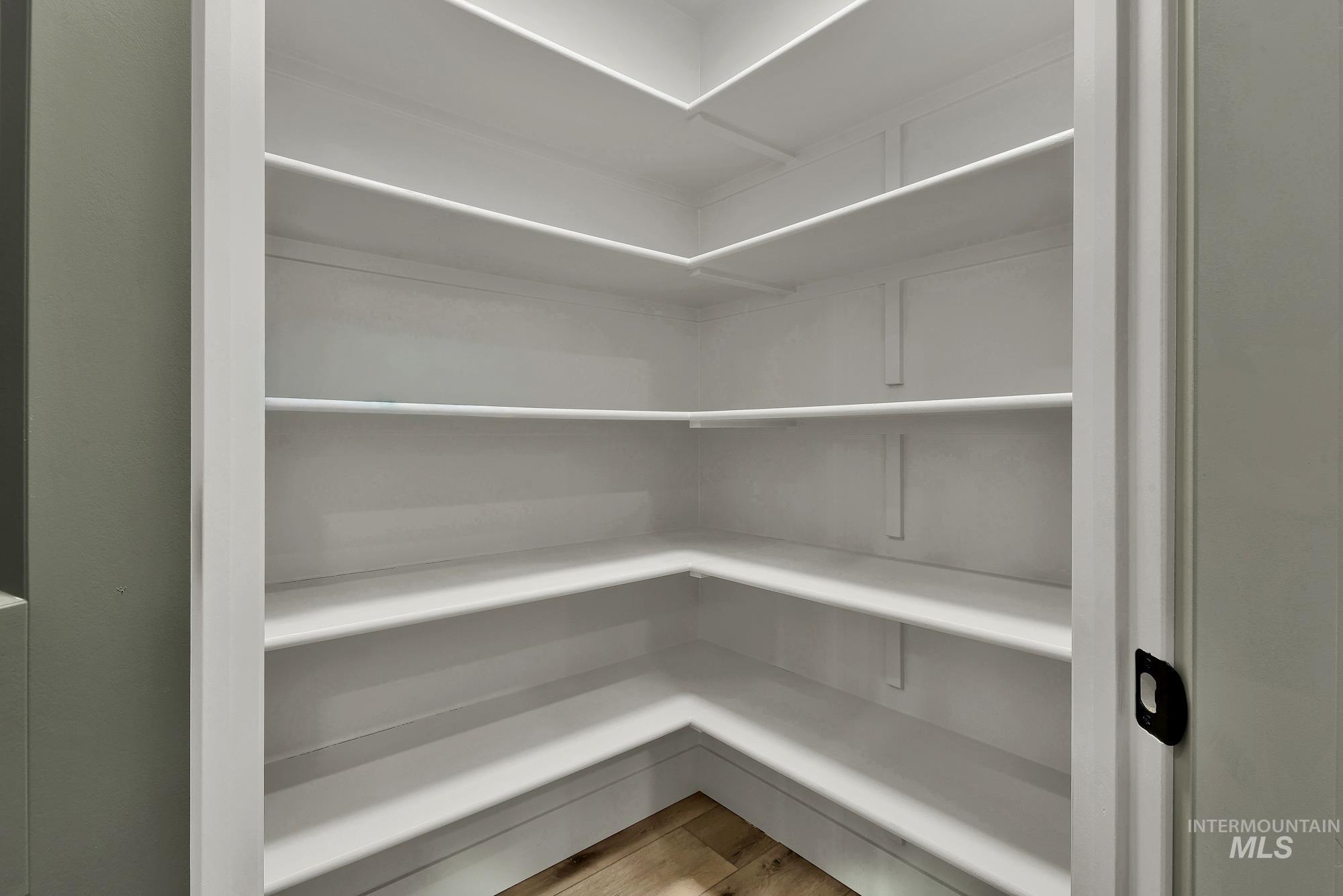 1130 Velvet Loop Wilder, ID 83676 - Photo 14 of 35 Built-in pantry featuring multiple white shelves and wood-finish flooring