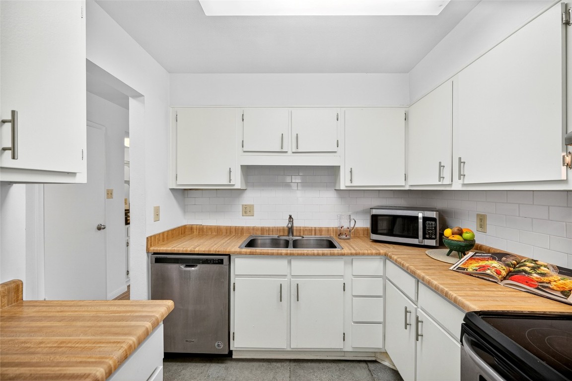 5000 Milwee Street, Unit 61 Houston, TX 77092 - Photo 21 of 42 a kitchen with stainless steel appliances granite countertop a sink stove refrigerator and white cabinets
