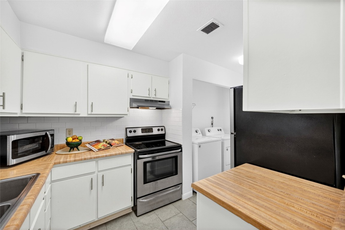 5000 Milwee Street, Unit 61 Houston, TX 77092 - Photo 25 of 42 a kitchen with a refrigerator stove and white cabinets