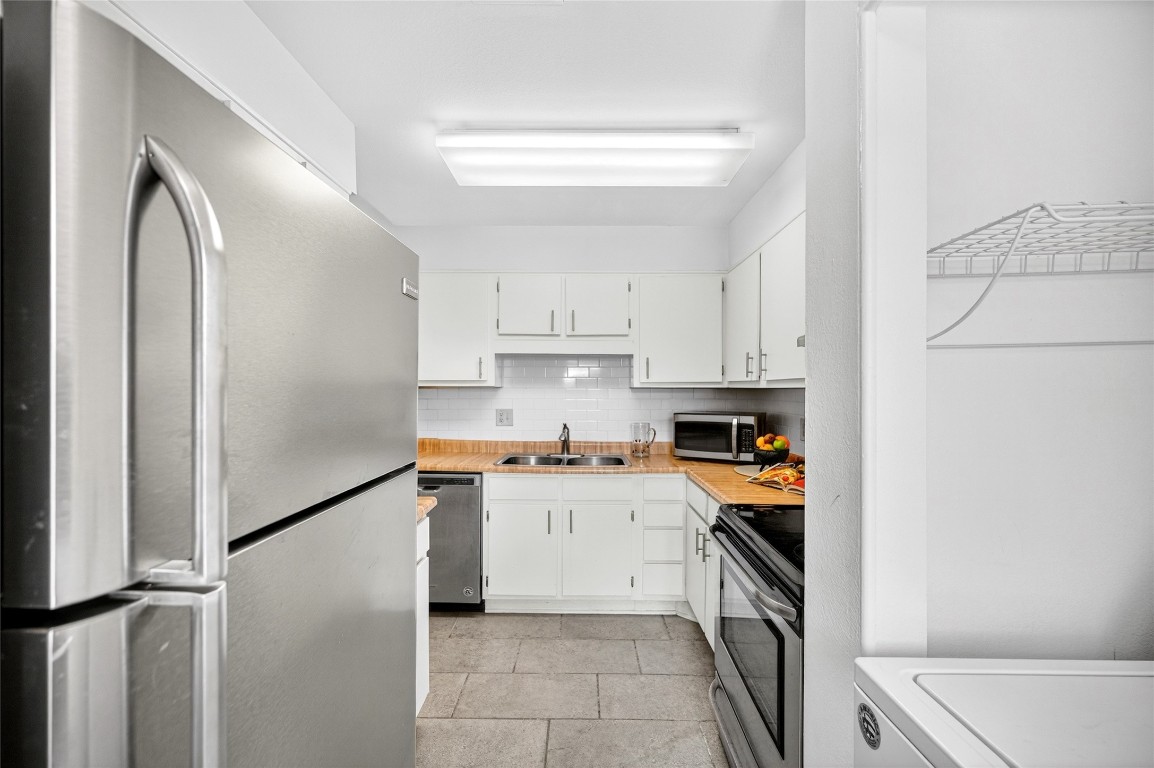 5000 Milwee Street, Unit 61 Houston, TX 77092 - Photo 35 of 42 a kitchen with stainless steel appliances granite countertop a refrigerator and a stove top oven