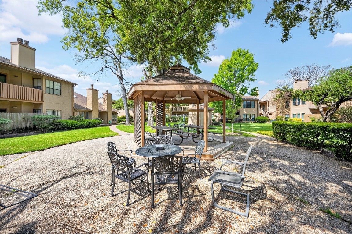 5000 Milwee Street, Unit 61 Houston, TX 77092 - Photo 39 of 42 a view of a patio with a table and chairs under an umbrella