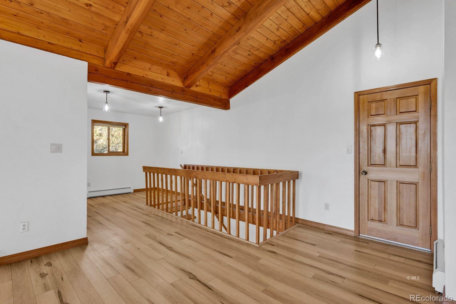 820 Schulze Ranch Road Westcliffe, CO 81252 - Photo 18 of 39 a view of a hallway with wooden floor