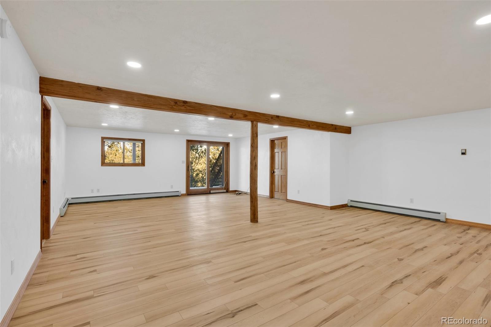 820 Schulze Ranch Road Westcliffe, CO 81252 - Photo 22 of 39 a view of an empty room with wooden floor and a window