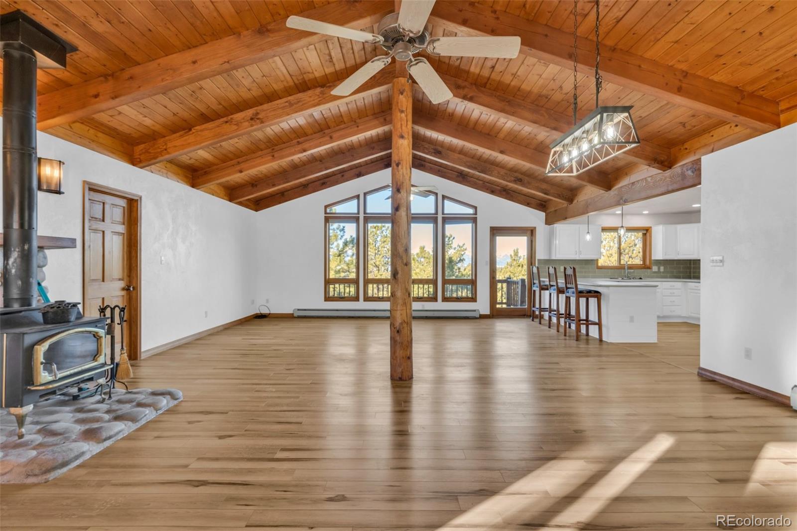820 Schulze Ranch Road Westcliffe, CO 81252 - Photo 6 of 39 a view of an empty room with wooden floor and a window