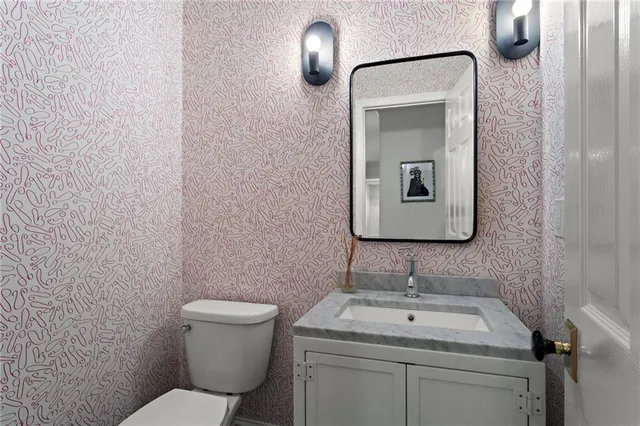 a bathroom with a toilet a sink and mirror