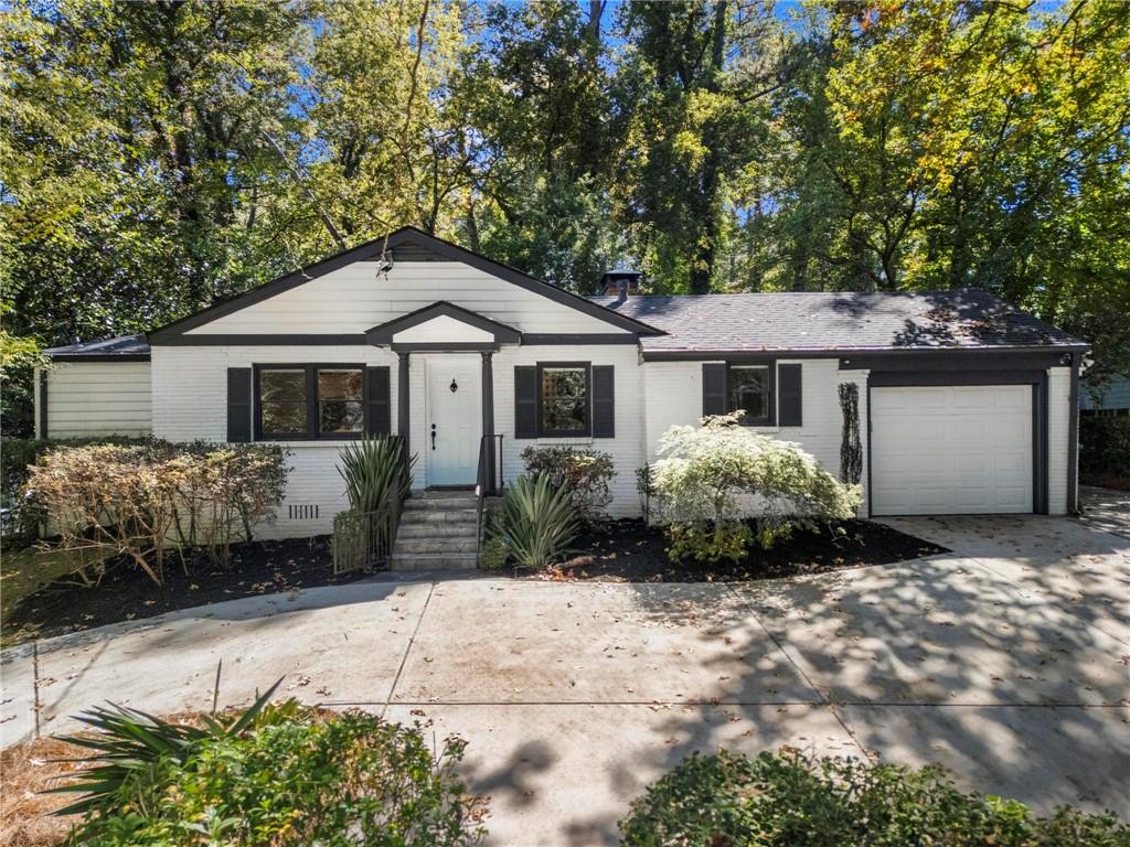 1788 Moores Mill Road Northwest Atlanta, GA 30318 - Photo 23 of 25 a front view of a house with a garden