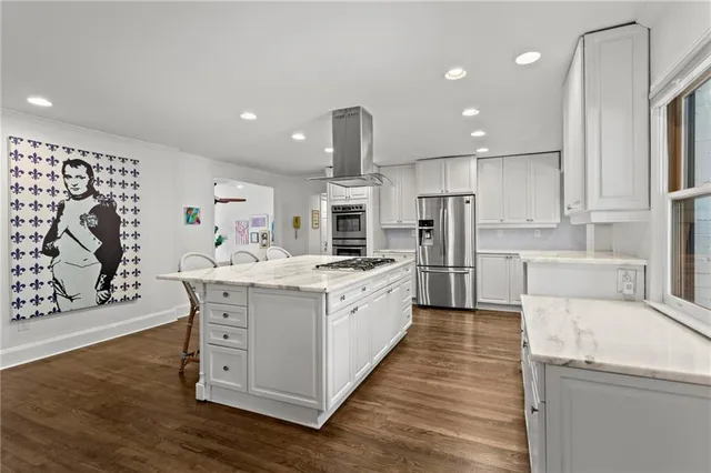a large kitchen with stainless steel appliances kitchen island granite countertop a stove and a sink