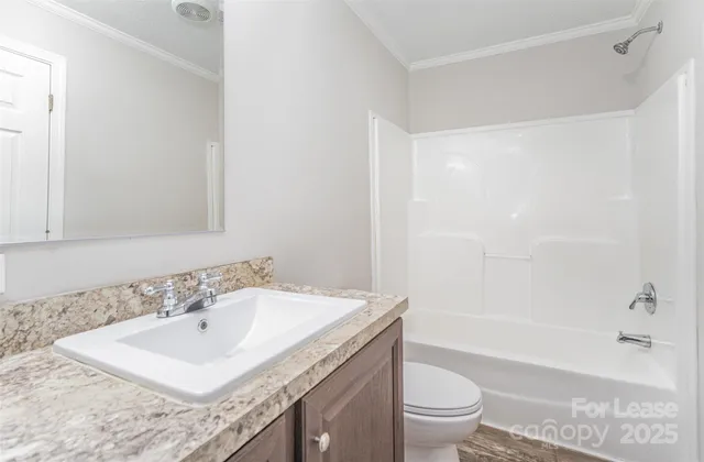 a bathroom with a granite countertop sink a toilet and a bathtub