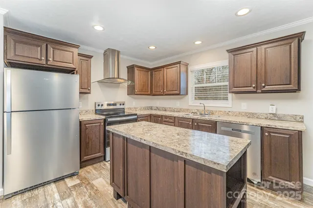 a kitchen with granite countertop a refrigerator stove top oven and sink
