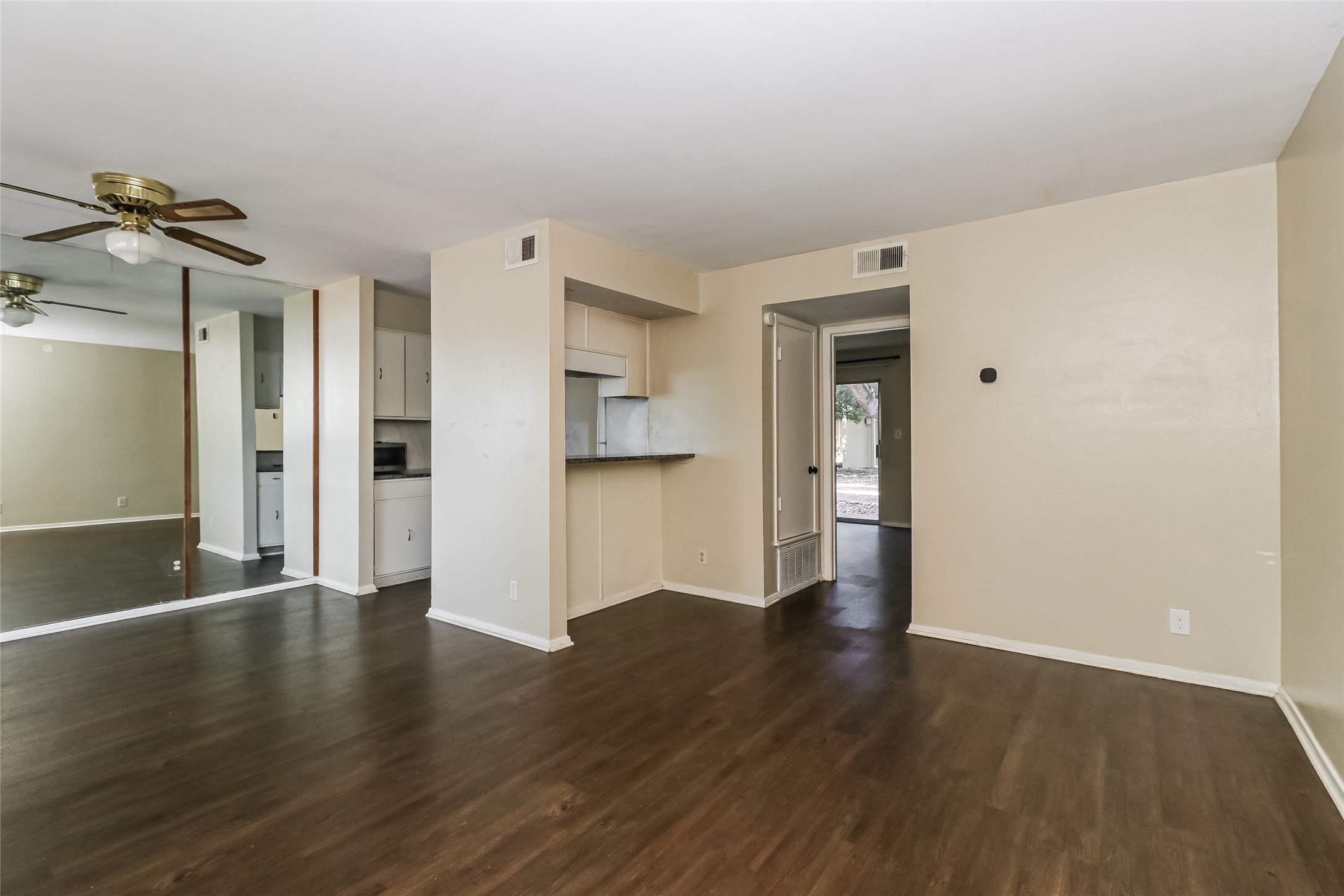 500 East Riverside Drive, Unit 135 Austin, TX 78704 - Photo 3 of 16 Unfurnished living room with a ceiling fan and dark wood finished floors