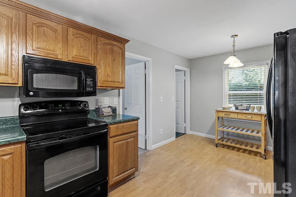 3304 Blue Ridge Road Raleigh, NC 27612 - Photo 12 of 34 a kitchen with a stove a microwave and a window