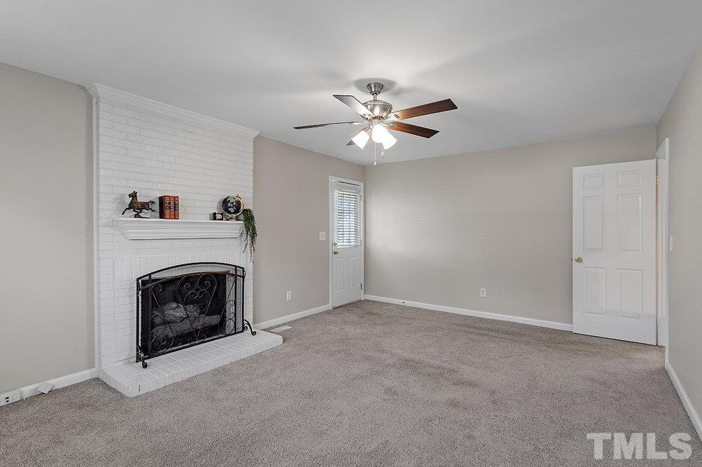 3304 Blue Ridge Road Raleigh, NC 27612 - Photo 16 of 34 a living room with a fireplace and a ceiling fan