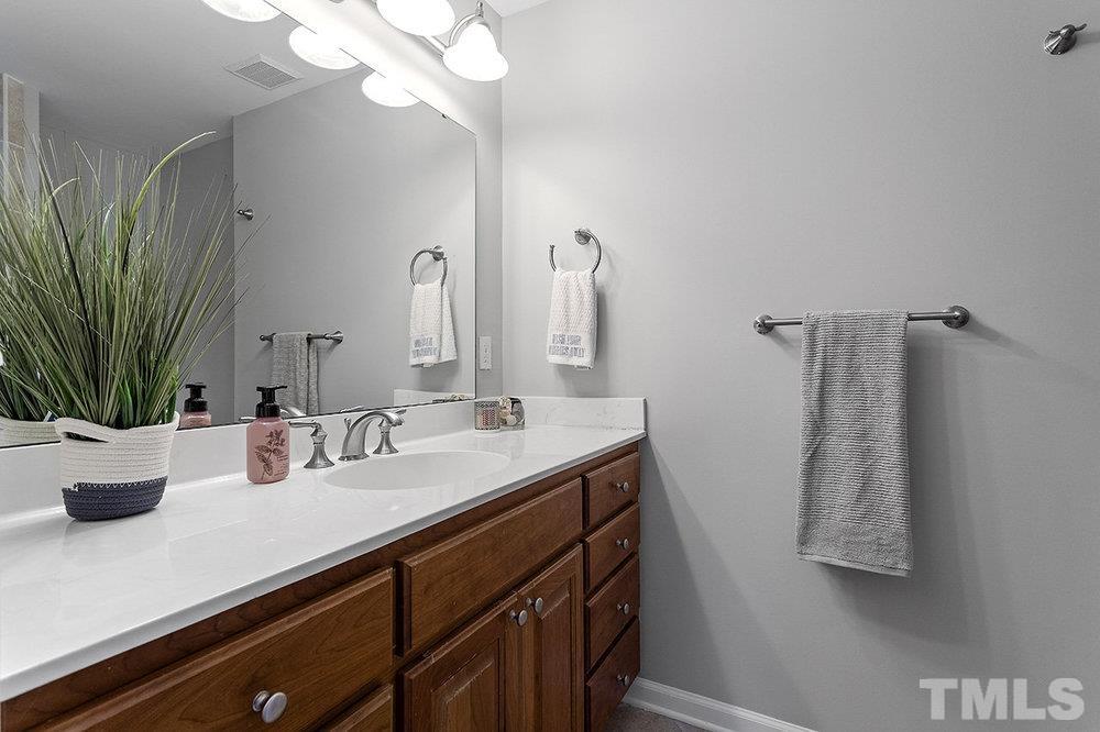 3304 Blue Ridge Road Raleigh, NC 27612 - Photo 26 of 34 a bathroom with a sink a mirror and vanity