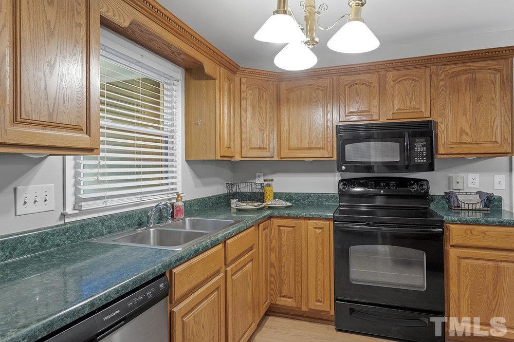 3304 Blue Ridge Road Raleigh, NC 27612 - Photo 9 of 34 a kitchen with granite countertop a stove sink and microwave