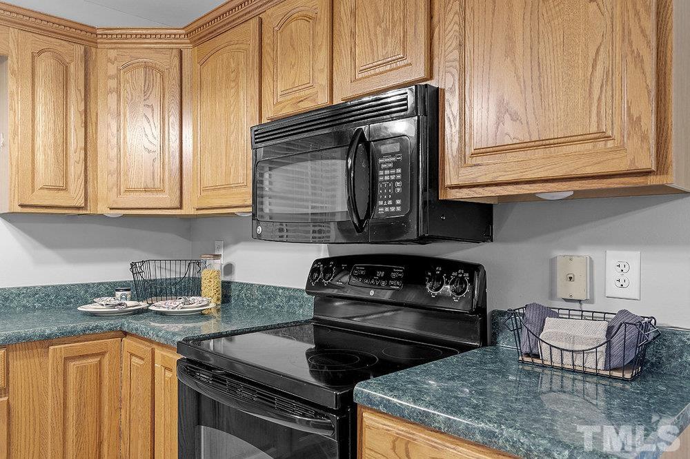 3304 Blue Ridge Road Raleigh, NC 27612 - Photo 10 of 34 a kitchen with granite countertop a stove sink and cabinets